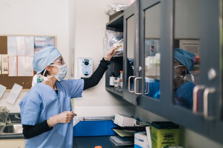 doctor reaches towards shelf scaled 1