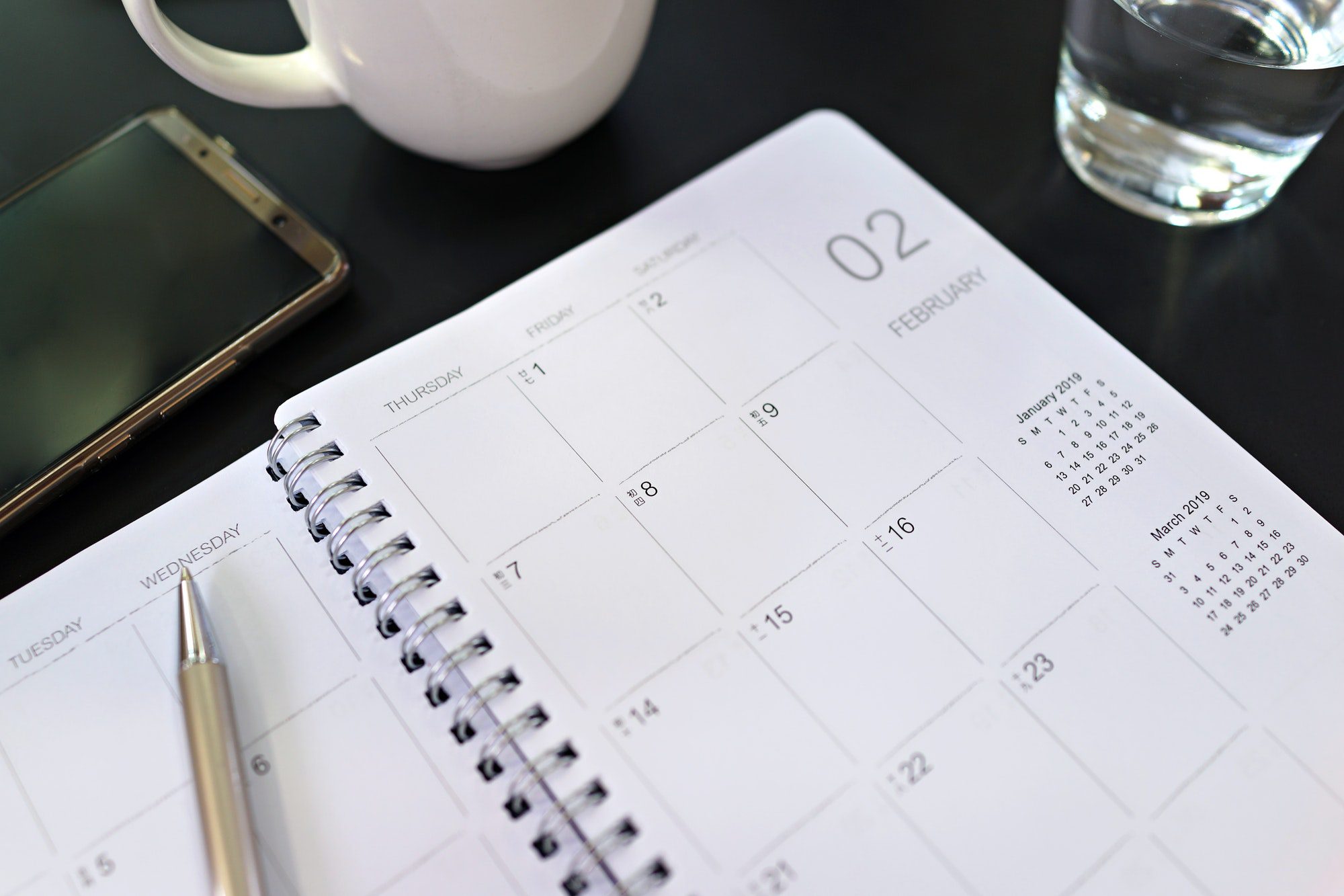 Calendar planner and mobile phone on desk