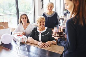 Senior woman with family and friends celebrating a birthday indoors