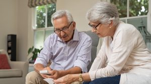 senior couple calculating expenses e1641426332988