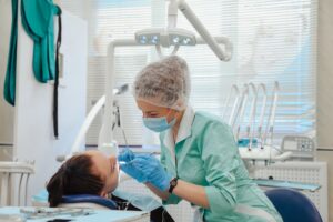 The dentist performs a dental examination in the patient's dental office